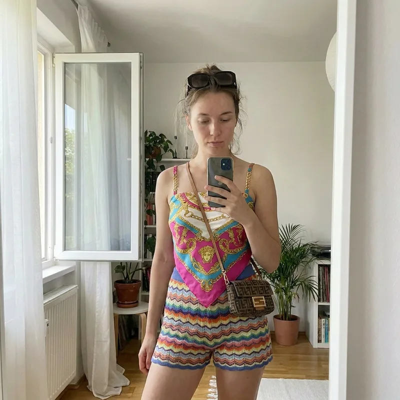 The same woman wearing a colorful silk top and knit shorts after virtual clothes try on